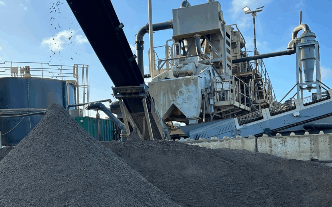 Aggregates falling off a conveyor belt with blue skies